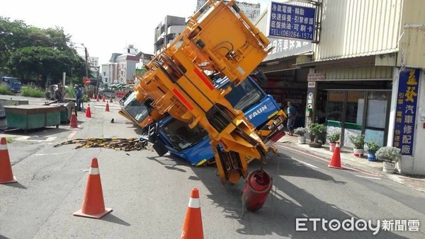 ▲台南市南區利南街驚傳道路塌陷吞60噸重大吊車事件，一輛60噸大吊車，從新興路倒車要進利南街工地時，右側車體突然傾斜陷入道路塌陷的坑洞中，現場鎖管制。（圖／記者林悅翻攝，下同）