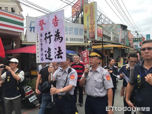 ▲反年金改革民眾結集嘉藥前方向蔡英文總統抗議，台南市警歸仁分局長梁仁輝依法舉牌警告。（圖／記者林悅攝，下同）