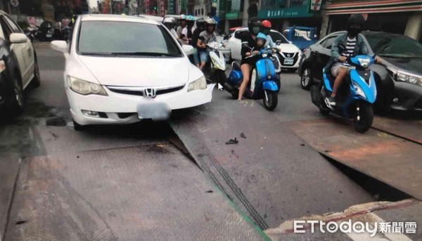 ▲一輛轎車行駛在一部水泥預拌車後方，不料大車壓過路面上的鐵板時，造成鐵板當場翹起，隨後而來的小客車來不及反應，被鐵板插中車頭凹損。（圖／記者林悅翻攝）