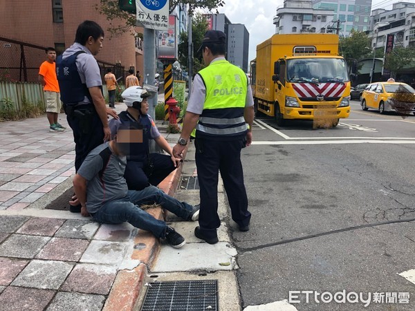 ▲▼一名男子在大街上持刀攻擊民眾，警方到場將他壓制。（圖／記者宋德威攝，下同）