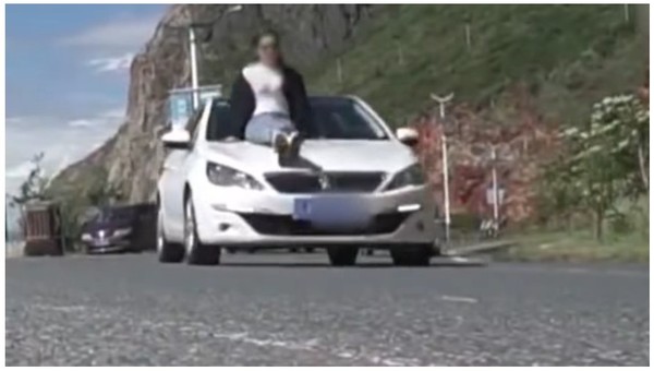 最狂出遊照！他讓女友人傲頂「車頭燈」　坐引擎蓋兜風。（圖／翻攝自新聞資訊熱點的YouTube）