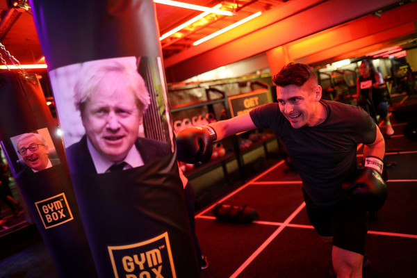 ▲▼英國脫歐（Brexit）談判陷入僵局，當地的健身中心Gymbox觀察到人民怒氣滿點，便開設了特定的課程，包括30分鐘的「梅伊布袋競賽」（Theresa May Sack Race），使用者可以用印有英國首相的麻布袋向前跳躍，也能打擊有著英國前外交大臣強生（Boris Johnson）照片的沙包。（圖／路透）