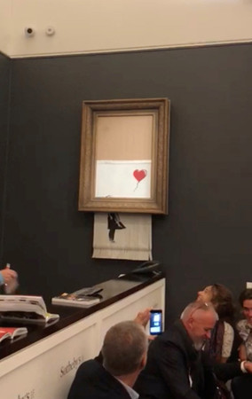 ▲▼ 英國街頭藝術家班克斯（Banksy）的畫作「氣球女孩」（Girl With Balloon）5日成交落槌後，但畫作卻在拍賣會場「自毀」變成碎紙。（圖／路透）