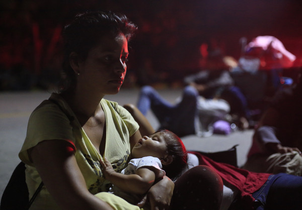 ▲▼一位中美洲移民在墨西哥的公路邊哄睡孩子，希望能攔到便車送她們一程。（圖／達志影像／美聯社）