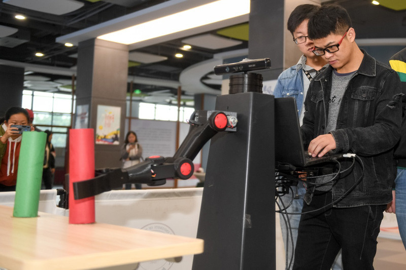 ▲合肥工業大學學生在操作一款服務機器人。（圖／翻攝自新華社）