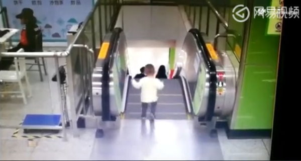 2歲童雙腿懸空差1秒摔下電扶梯　包頭女衝刺護脖抱起！驚險14秒曝光。（圖／翻攝《網易視頻》）