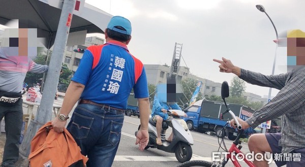 ▲一名騎著單車的男子（右），口出狂言飆罵維持秩序的義勇軍。（圖／記者宋德威攝）