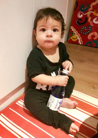 ▲艾莉絲9個月大的兒子偷拿酒瓶。（圖／翻攝自臉書／艾莉絲 X  IRIS）