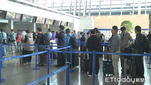 ▲上海浦東機場的櫃台前，許多台灣民眾排隊辦裡登機證。（圖／記者魏有德攝）