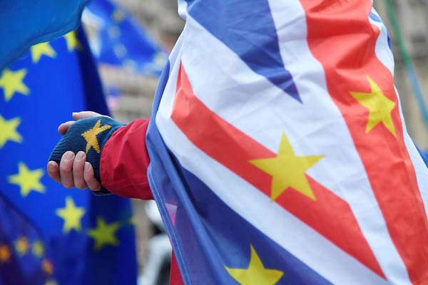 ▲▼在進行脫歐協議談判的同時，英國反脫歐人士將歐洲12星旗與國旗結合，披在肩上以表達自己的立場。（圖／路透）