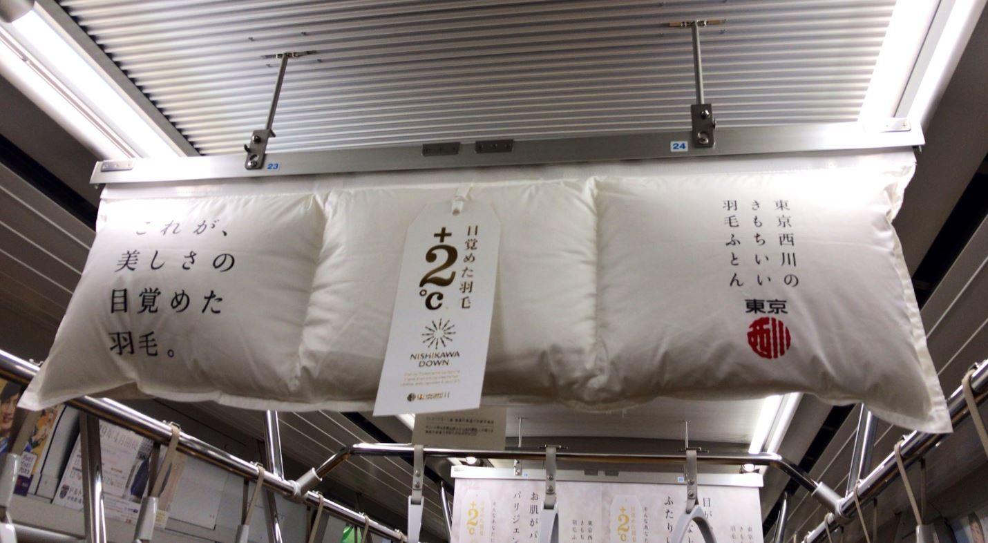 ▲▼有床具業者在東京地鐵掛羽絨被來打廣告。（圖／翻攝自Twitter／@sugaya_ayumu）