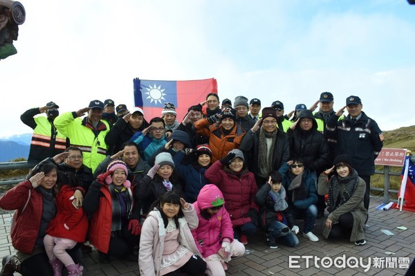 ▲勤務人員邀請武嶺停車場等待下雪的遊客，在1.9度的低溫中一起加入全台最高海拔升旗典禮。（圖／新城分局提供，下同）