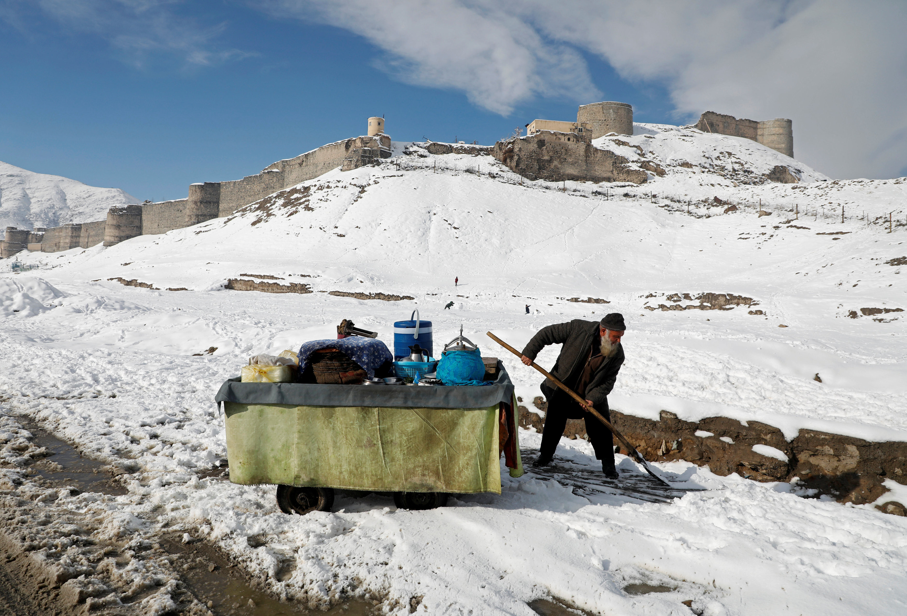 ▲阿富汗喀布爾冬天第一場雪。阿富汗一名男子在他的手推車旁邊除雪。採礦山難發生在科希斯坦縣（Kohistan）下大雪期間。（圖／路透社）