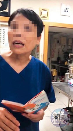 身穿藍衣拿著狗狗健康護照為寵物進行檢診的是「無照女獸醫」林美玲。（讀者提供）