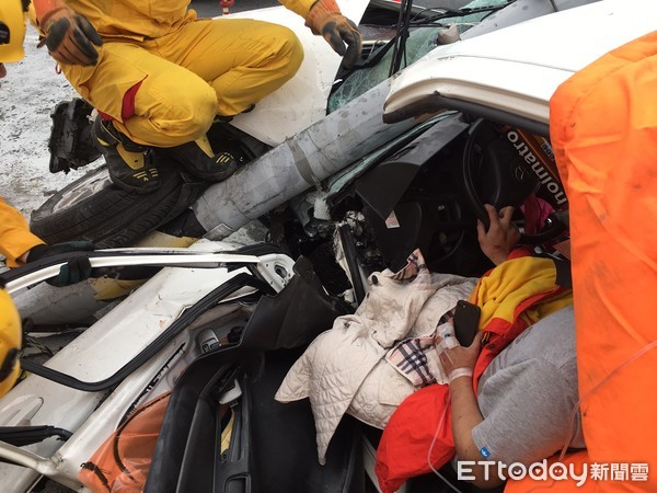 ▲台南市永康區永安路發生1起自小客車撞上路邊路燈，車頭嚴重變形，駕駛受困駕駛座上，消防人員全力搶救脫困送醫。（圖／記者林悅翻攝，下同）