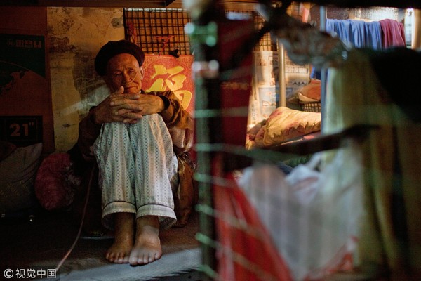 ▲▼78歲老人梁書（音譯）居住在“籠屋”裏。香港人口稠密，為數不少的老弱貧苦人聚居在這種各以鐵絲網圍住的舊樓床位內。（圖／CFP）