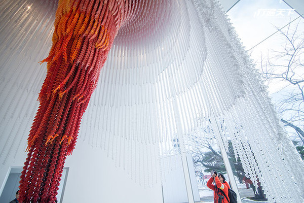 ▲韓國藝術家徐道獲的Causeand Effect，用1萬個塑膠小人串成9公尺高長的放紙狀吊燈，意味人生輪廻因果。（圖／行遍天下）