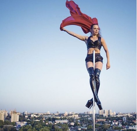 ▲俄羅斯鋼管舞者瑪琳娜在大樓樓頂的天線桿 上大跳鋼管舞，驚險萬分。(圖／翻攝自YouTube)