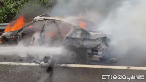 ＢＭＷ國道上擦撞護欄後起火燃燒，熊熊大火將車燒成只剩下骨架。（圖／記者黃孟珍翻攝）