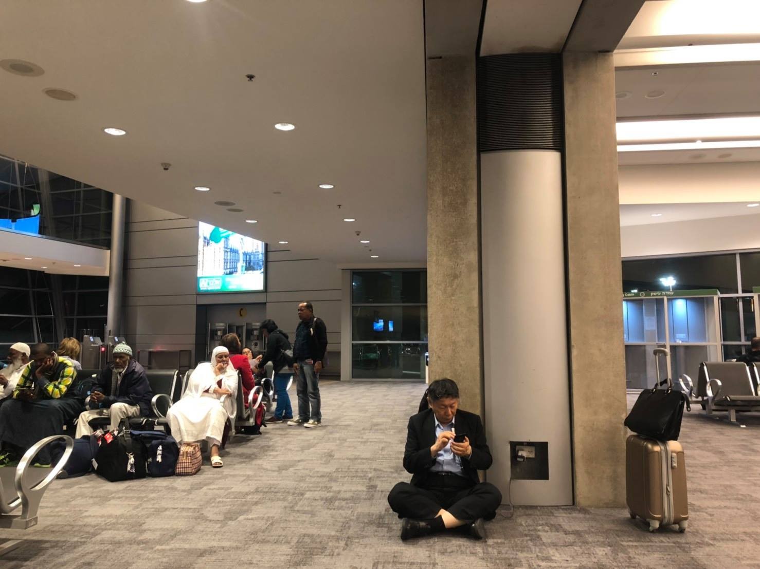▲▼台北市長柯文哲在以色列機場席地充電。（圖／取自臉書）
