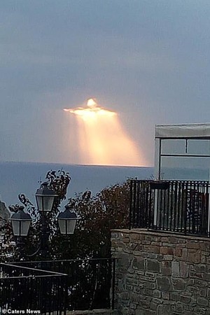 ▲義大利小鎮的天空浮現奇景：當陽光穿透雲層時，顯示出金光閃閃的耶穌基督圖象。(圖／翻攝自網路)