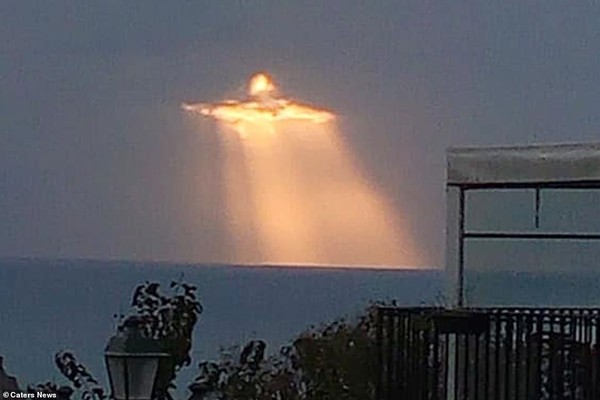 ▲義大利小鎮的天空浮現奇景：當陽光穿透雲層時，顯示出金光閃閃的耶穌基督圖象。(圖／翻攝自網路)