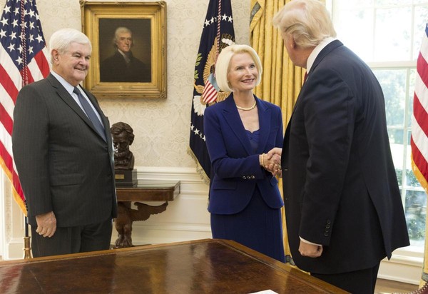 2018年3月16日，美國總統川普在白宮接見前眾院議長金瑞契（左），他的妻子卡麗斯塔（中）被川普任命為新任駐教廷大使。Psy Group曾想透過金瑞契牽線參與川普的選戰業務。（東方IC）