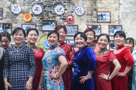 ▲來自清涼峰鎮的部分鄉村女性代表身著旗袍在改造好的民居前合影。（圖／新華社提供）