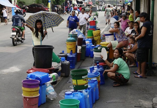 ▲馬尼拉居民排隊，旁邊放著大小桶子，期盼著水車的到來。（圖／EPA Philippines）