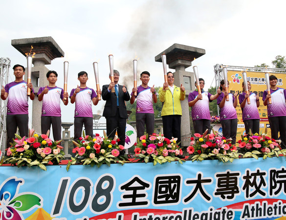 ▲▼108全大運25日在中正大學噴水池廣場舉行「聖火引燃」儀式，現場邀請超馬選手陳彥博（左五）、中正大學馮展華校長（左四）、登7頂峰的女勇士江秀真（右四）、教育部體育署副署長王水文（右五）與聖火隊學生一同點燃手上的火把。（圖／中正大學提供）