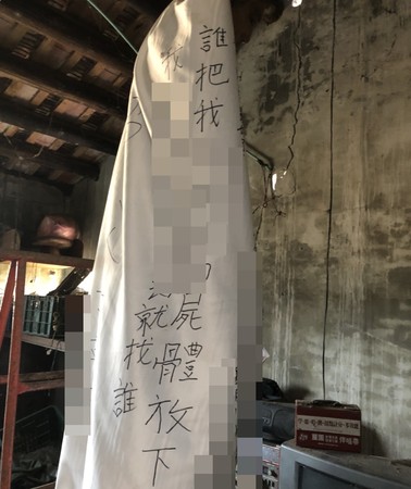 ▲桃園市新屋區古姓男子因買賣古厝與人訴訟被判敗訴定讞，10日被家人發現在祖厝上吊自殺，裹著「誰將我屍體放下，我的冤魂就找誰！」布條。（圖／家屬提供）