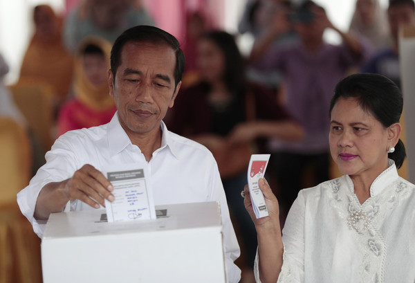 ▲印尼總統佐科威和夫人伊蘭妮亞投下神聖一票時的畫面。(圖／達志影像／美聯社)