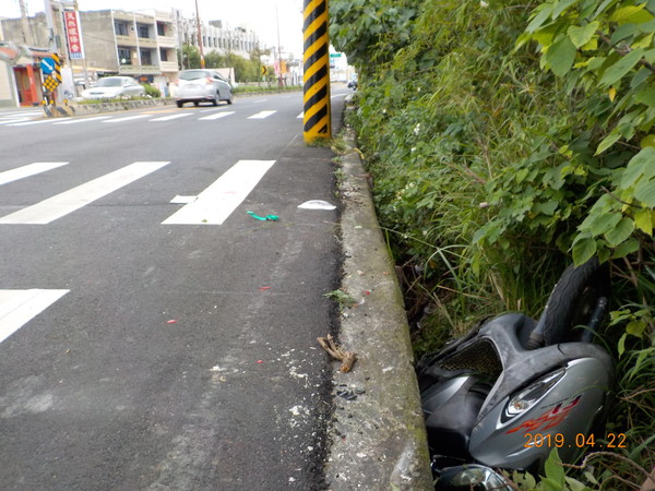 ▲婦人騎機車疑似與自小客車擦撞，摔落50公分深的草叢內。（圖／記者唐詠絮翻攝）