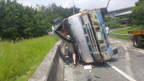 ▲王田交流道下，混泥土車翻覆，駕駛腿外露。（圖／記者唐詠絮翻攝）