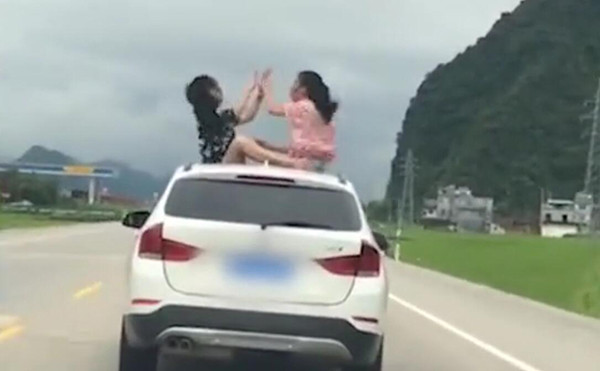 ▲▼ 坐BMW車頂猜拳。（圖／翻攝自秒拍）