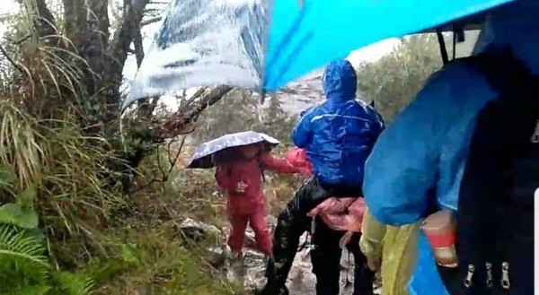 ▲▼女登山客攻頂玉山遭雷擊，救難人員採人工背負方式協助將其送下山後送醫院。（圖／記者翁伊森翻攝，下同）