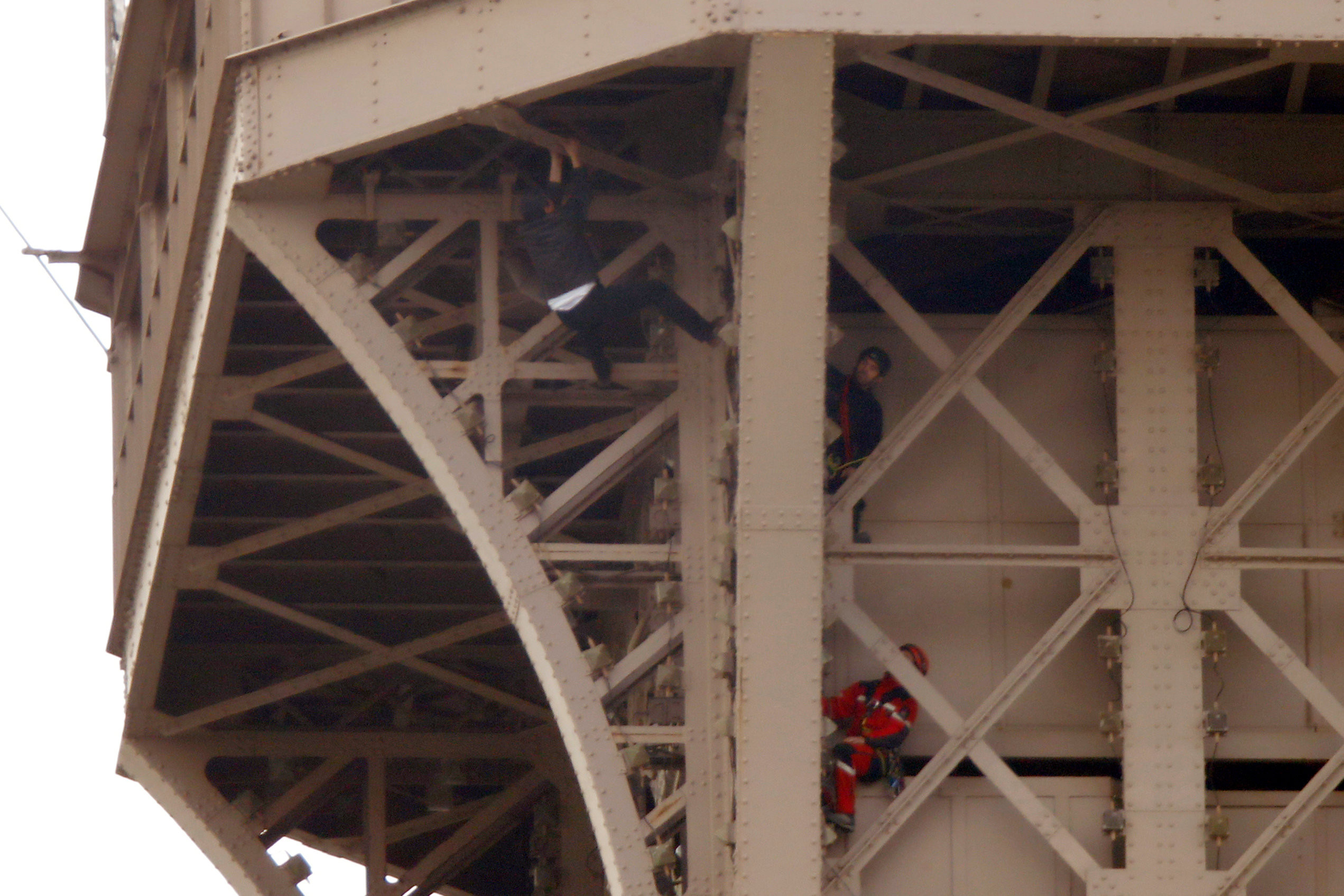 ▲法國黑衣男徒手爬上巴黎艾菲爾鐵塔（Eiffel Tower）。（圖／路透社）