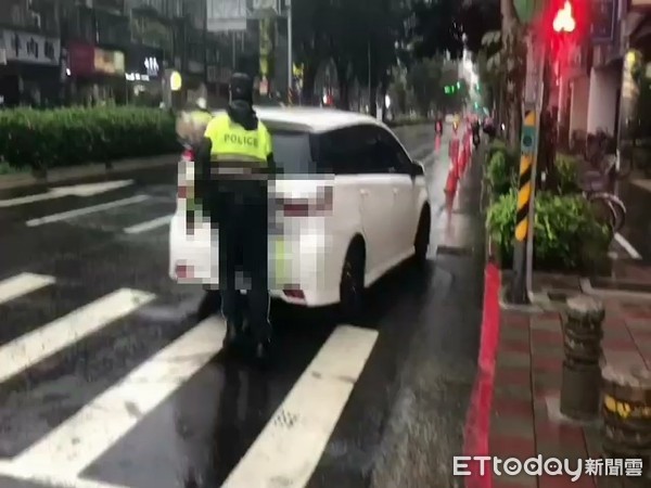 ▲大安分局臥龍所警員冒雨推車紓解車流。（圖／記者張君豪翻攝）