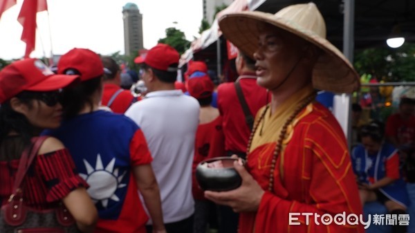 ▲被花蓮韓粉封為「護國大法師」現身台中場，不過這次中暑了，請人刮痧幫忙             。（圖／記者吳奕靖攝）