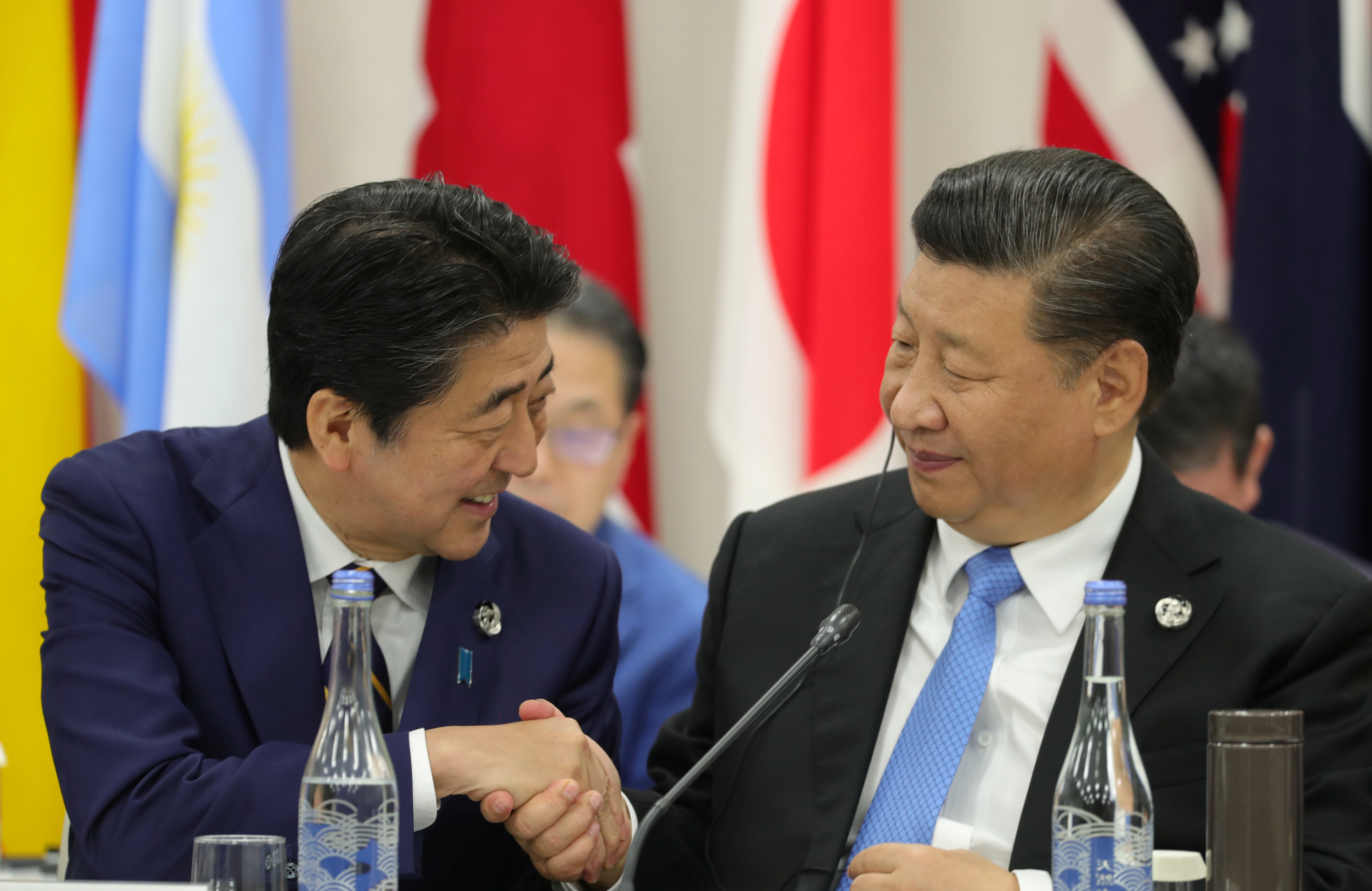 ▲習近平(右)在G20峰會上跟日本首相安倍晉三握手致意。(圖／路透）