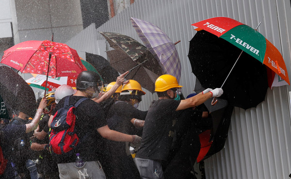 ▲香港示威民眾衝撞立法會，警察亮紅旗。（圖／路透）