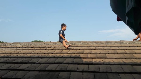 ▲▼印尼5歲男孩不願接受割禮，逃到屋頂上。（圖／翻攝自Facebook／Anik Sutari）