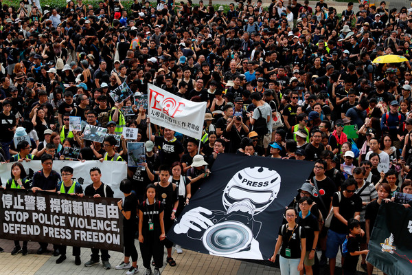 ▲香港新聞界遊行，參與者身著黑衣或反光背心表達訴求。（圖／路透社）