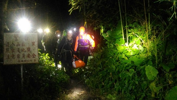 ▲搜救人員以人力搬運、登山魂斷桃園的楊男大體抵登山口。（圖／消防局提供）