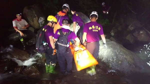 ▲搜救人員以人力搬運、登山魂斷桃園的楊男大體抵登山口。（圖／消防局提供）