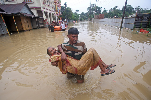 ▲▼暴雨侵襲印度，一名婦女受到救援。（圖／路透）