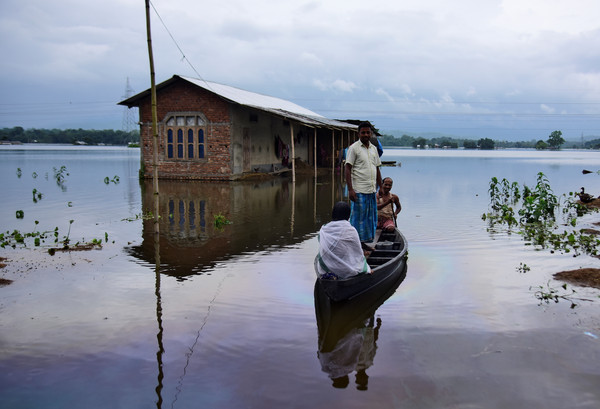 ▲▼印度東北部阿薩姆邦一處村莊被洪水淹沒，居民等著乘船前往更安全的地點。（圖／路透）