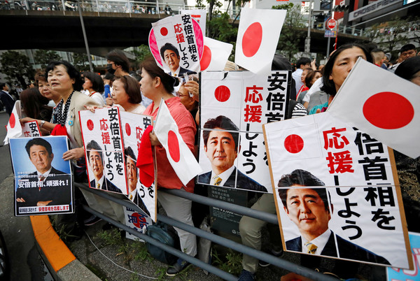 ▲▼2019/07/20，日本參議院改選前最後一天，安倍晉三的支持者在東京街頭揮舞標語。（圖／路透）