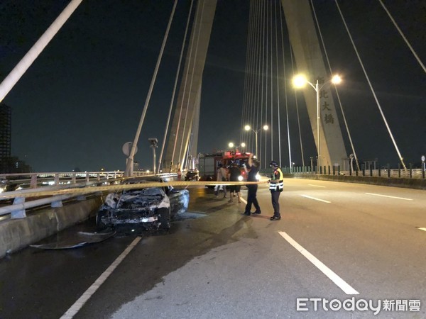 ▲▼吳姓女子駕駛一輛BMW轎車行經新北大橋時，因不明原因起火自燃，警消獲報趕抵現場協助滅火。（圖／記者趙永博攝）