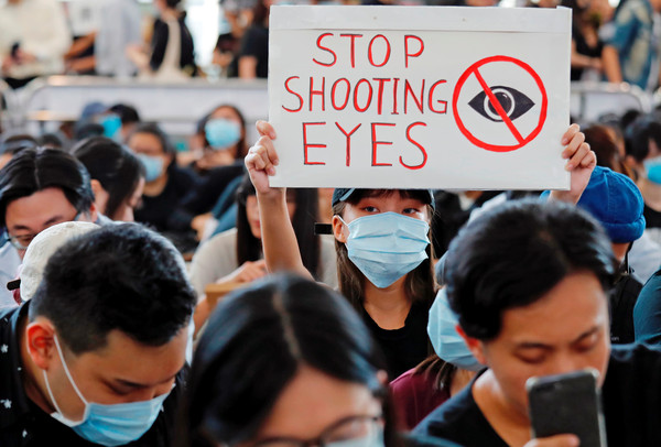 ▲香港機場「警察還眼」集會，聲援受傷少女。（圖／路透社）